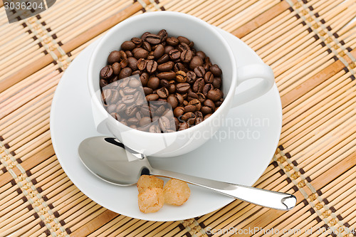 Image of cup with a spoon and sugar with coffee beans