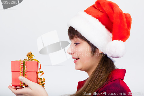 Image of blue-eyed beautiful girl in santa hat with presents