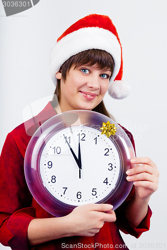 Image of blue-eyed beautiful girl in santa hat with clock