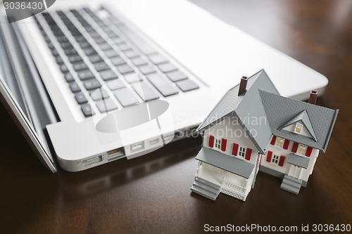 Image of Miniature House And Laptop Computer