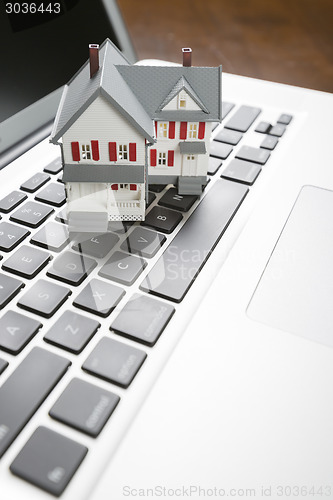 Image of Miniature House on Laptop Computer