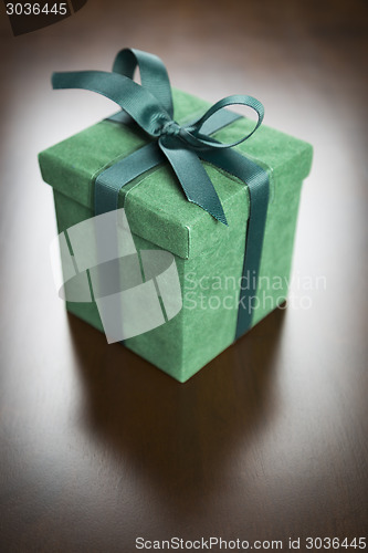 Image of Green Gift Box with Ribbon and Bow Resting on Wood