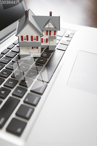 Image of Miniature House on Laptop Computer
