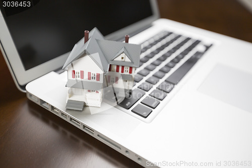 Image of Miniature House on Laptop Computer