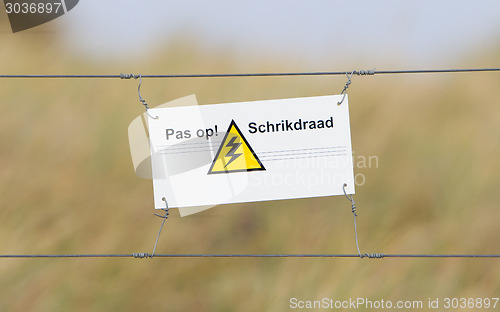 Image of Border fence - Old plastic sign with a flag