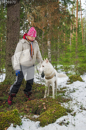 Image of The woman with a dog on walk in a winter wood