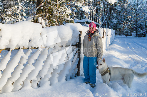 Image of The woman with a dog on walk in a winter wood