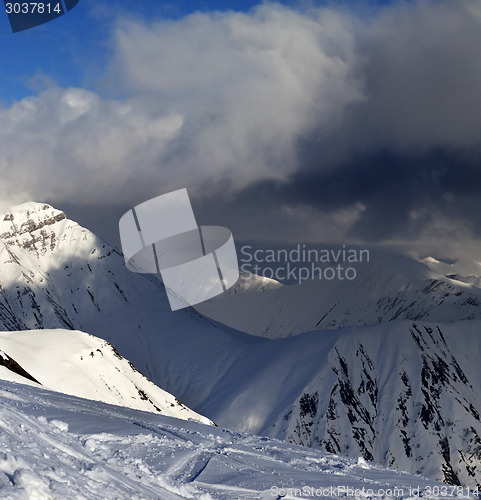 Image of Off-piste slope and mountains with storm clouds