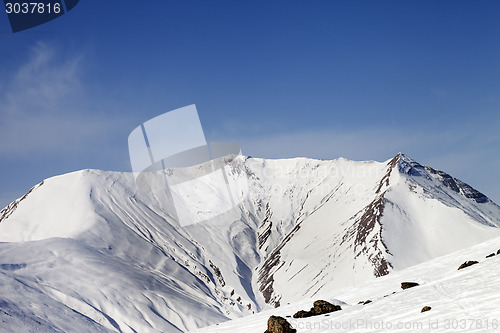 Image of Off-piste slope with stones and snowy mountains