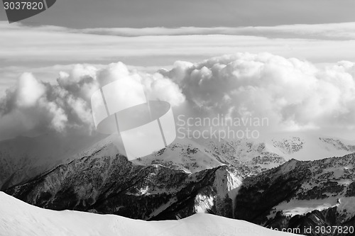 Image of Black and white snowy mountains in clouds and off-piste slope