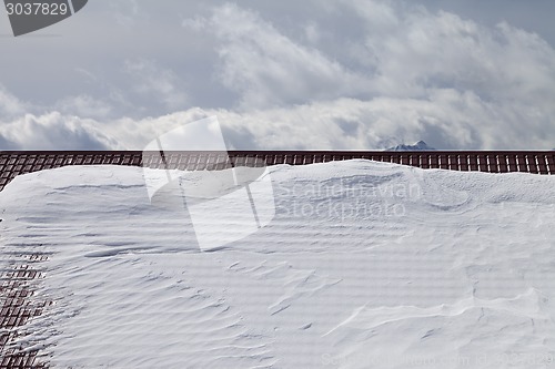 Image of Snowy roof and cloudy sky