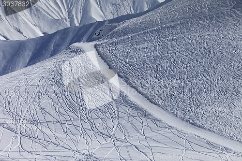 Image of Off-piste slope and road with trace from ski and snowboards