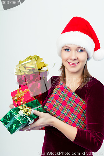 Image of happy girl in santa hat with gift boxes