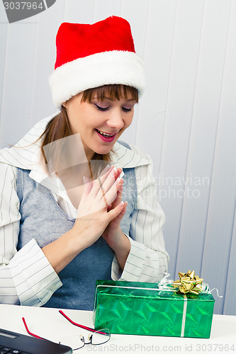 Image of girl in the office in Santa hats with a gift