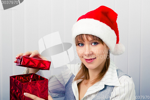 Image of girl in the office in Santa hats with a gift