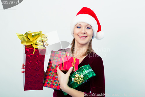 Image of happy girl in santa hat with gift boxes