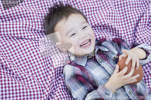 Image of Young Mixed Race Boy Playing with Football on Picnic Blanket
