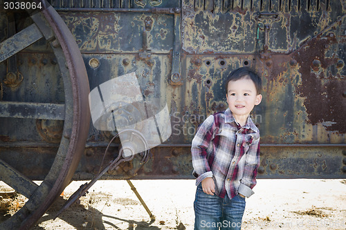 Image of Cute Young Mixed Race Boy Having Fun Near Antique Machinery