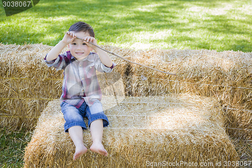 Image of Cute Young Mixed Race Boy Having Fun on Hay Bale