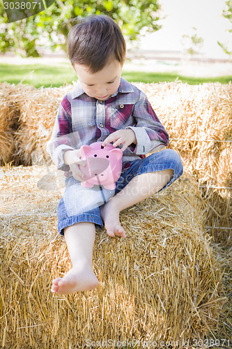 Image of Cute Young Mixed Race Boy Putting Coins Into Piggy Bank