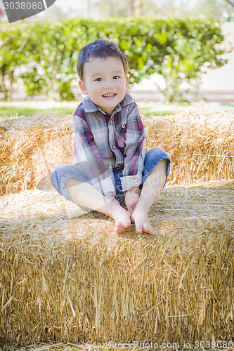 Image of Cute Young Mixed Race Boy Having Fun on Hay Bale