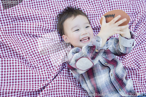 Image of Young Mixed Race Boy Playing with Football on Picnic Blanket