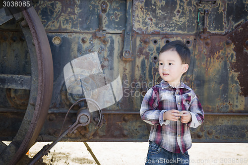 Image of Cute Young Mixed Race Boy Having Fun Near Antique Machinery