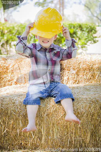 Image of Young Mixed Race Boy Laughing with Hard Hat Outside