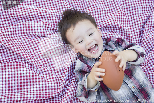 Image of Young Mixed Race Boy Playing with Football on Picnic Blanket