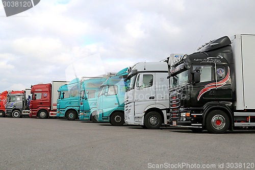 Image of Row of Colorful Trailer Trucks on a Yard