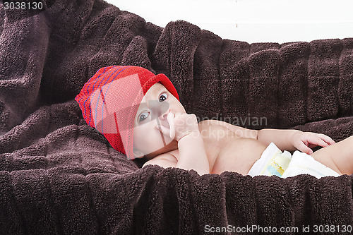 Image of Surprising baby boy over brown blanket
