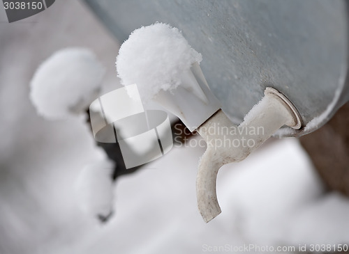 Image of two outdoor metal faucets covered by snow