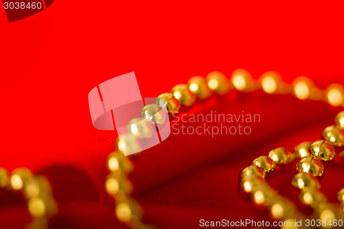 Image of card. Red fabric with festive beads