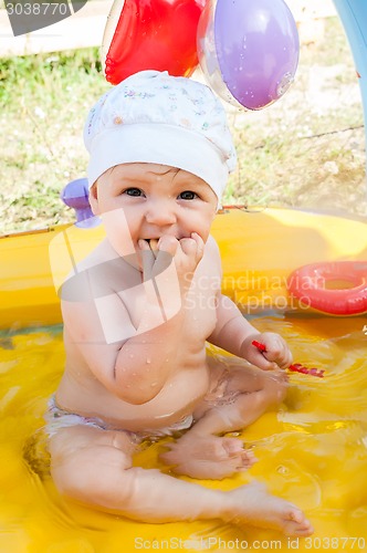 Image of Little 9 monthes old girl swims in pool