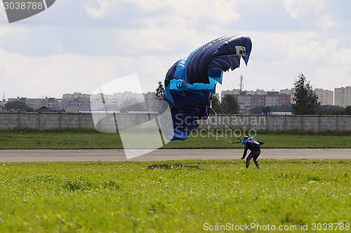 Image of the parachutist lands on a multi-colored parachute.