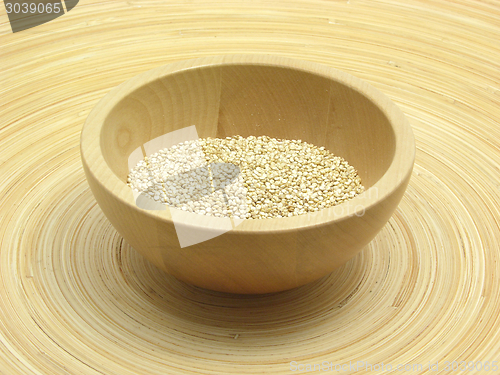 Image of Wooden bowl with quinoa on bamboo plate