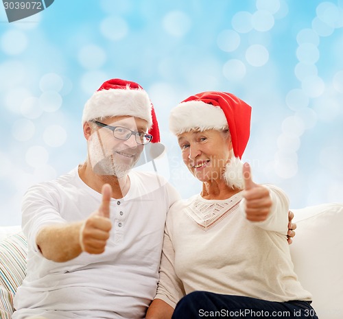 Image of happy senior couple in santa helper hats