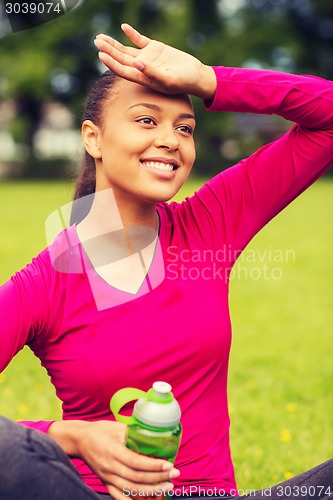 Image of smiling teenage girl showing bottle