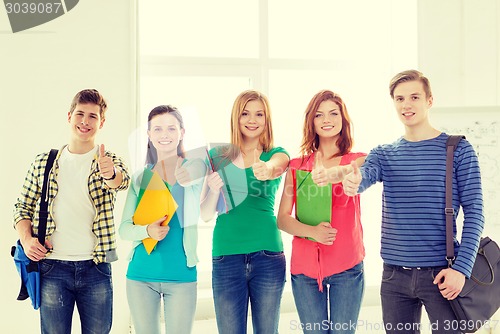 Image of smiling students with bags and folders at school