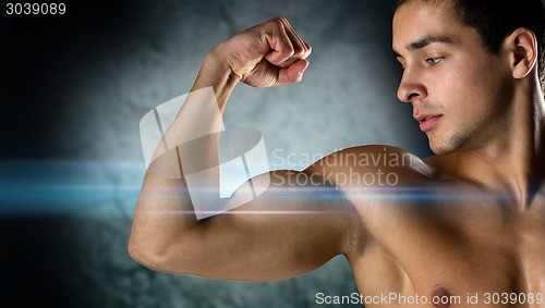 Image of close up of young man flexing and showing biceps