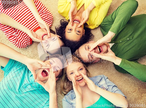 Image of smiling people lying down on floor and screaming