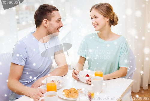 Image of smiling couple having breakfast at home