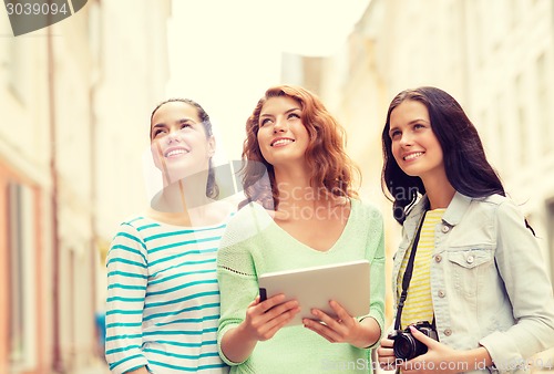 Image of smiling teenage girls with tablet pc and camera