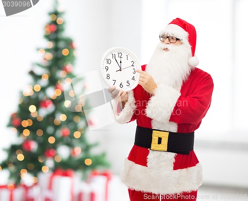 Image of man in costume of santa claus with clock