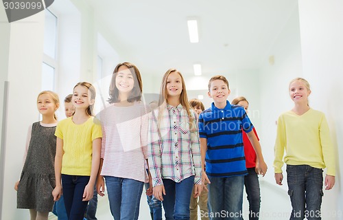 Image of group of smiling school kids walking in corridor