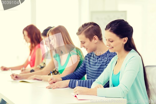 Image of smiling students with textbooks at school