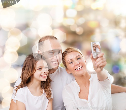 Image of happy family with camera at home