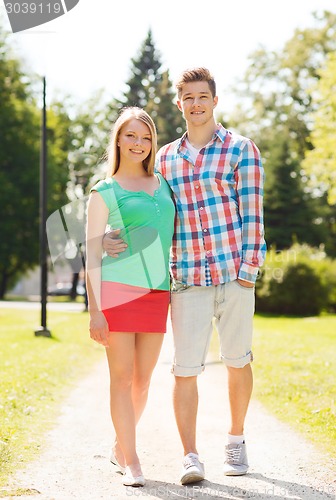 Image of smiling couple walking in park