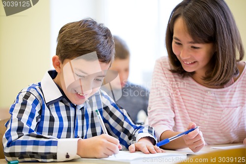 Image of group of school kids writing test in classroom