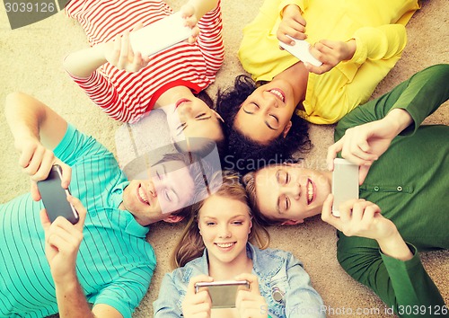 Image of group of smiling people lying down on floor